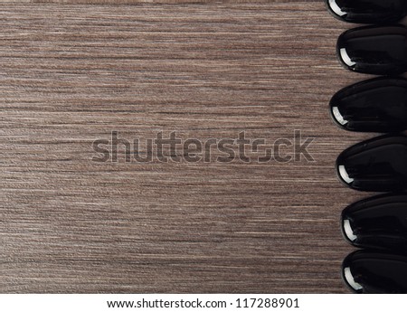 spa background and frame. black stones on wooden texture