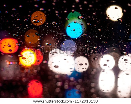 Rain drops on window with car light vintage color bokeh night light traffic jam ,City life in night in rainy season