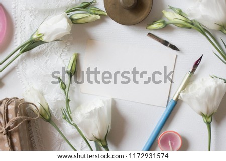 Minimalistic card mockup with eustoma, white flower, craft envelope, flat lay, top view white eustoma flowers. Workspace. Wedding invitation cards,  lisianthus with copy space