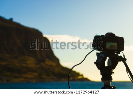 Professional camera on tripod taking picture film video from Monemvasia island, Greece Peloponnese Lakonia