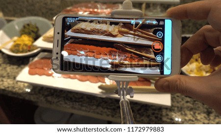 Food photo concept. A man is doing a photo of food using a smartphone.