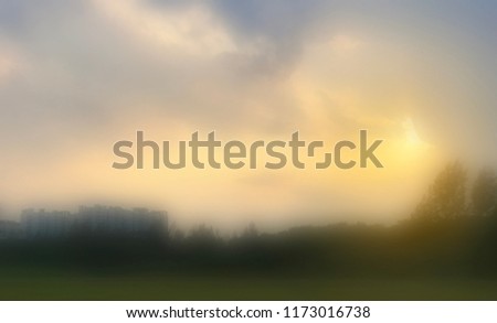 Blurred image/ Abstract of sunset/sunrise at empty open field near residential apartment