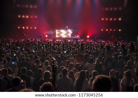people at the concert with the phones shoot the show