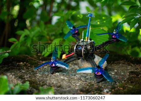 Blue race drone for fpv first person view for racing with quadcopters with carbon frame in nature green background.