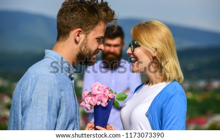 Lovers meeting outdoor flirt romance relations. Unrequited love concept. Couple in love dating while jealous husband fixedly watching on background. Couple romantic date lover present bouquet flowers. Royalty-Free Stock Photo #1173073390