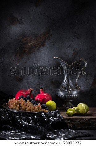 Still life with a jug of wine and fruit on a dark concrete background