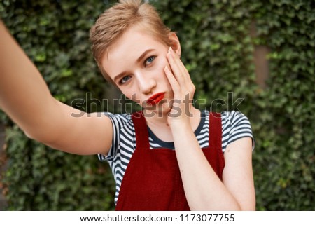 beautiful woman in a sarafan takes pictures of herself                               