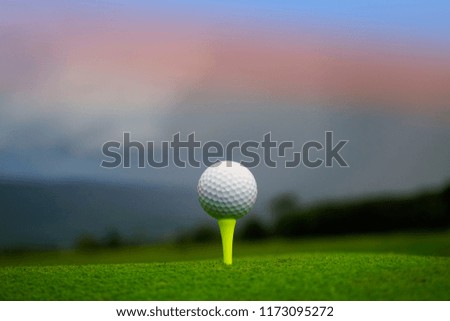 Golf ball on tee in beautiful golf course at sunset background. Golf ball on green in golf course at Thailand