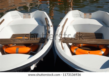 Top view of two old boats.There are a couple of bright lifebuoys in there. Beautiful and colorful picture of two vessels on the water closeup. Nice background. 