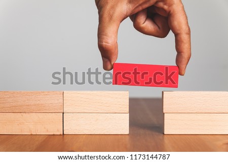 Putting a wooden block between gap, business concept Royalty-Free Stock Photo #1173144787