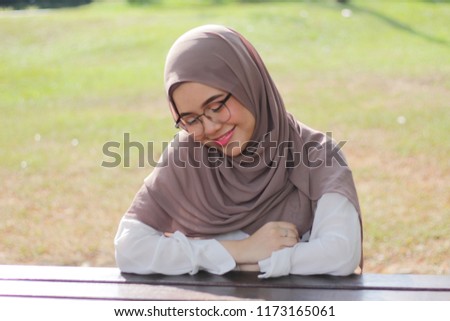 portrait of cute young hijab girl with expression on her face at the park around evening. Mood concept.