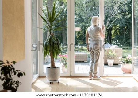 Lonely elderly woman in a nursing house with garden during sunny day