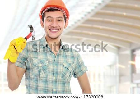 Portrait of an happy worker with hammer at construction sites