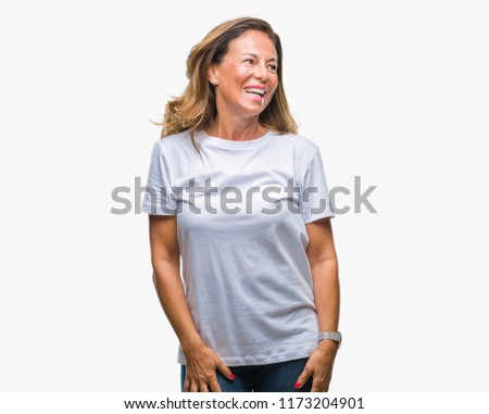 Middle age senior hispanic woman over isolated background looking away to side with smile on face, natural expression. Laughing confident.