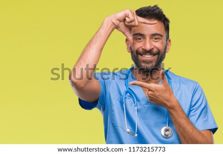 Adult hispanic doctor or surgeon man over isolated background smiling making frame with hands and fingers with happy face. Creativity and photography concept.