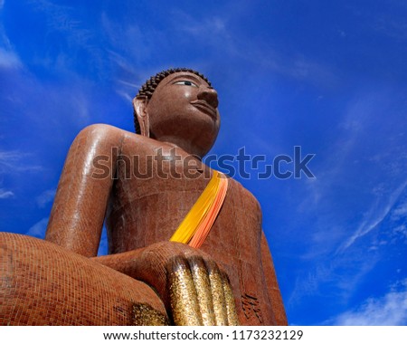 Statue of Buddha with sky background.