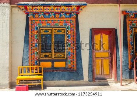 Old wall with window painted colorful in Tibetan style. Songzanlin Temple also known as the Ganden Sumtseling Monastery, is a Tibetan Buddhist monastery in Zhongdian city( Shangri-La), Yunnan China.