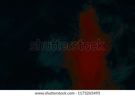 red paint dissolves under water on a dark background an exciting abstraction