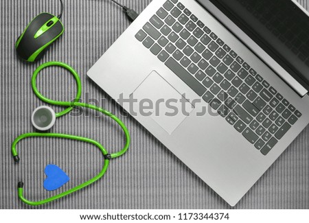 Laptop, stethoscope on a gray background, top view