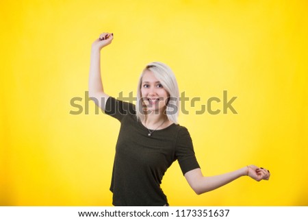 Portrait of a relaxed young woman with arms outstretched dreaming of vacation isolated over colorful yellow background.