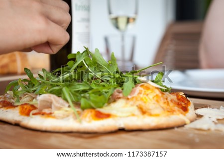 rocket parmesan pizza on wooden board