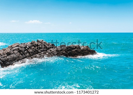 Blue Ocean or Blue Sea and rocks. Turquoise Sea Waves crashing and hitting on the rocks at the coast or shore of the ocean or sea. Beautiful scenic nature landscape.
