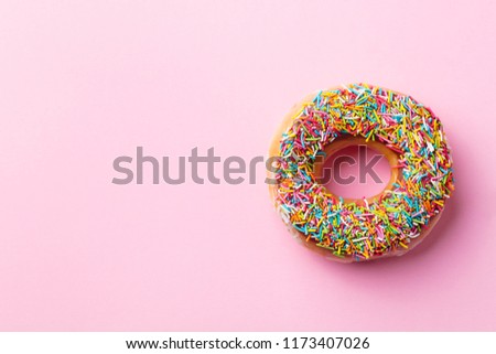 Donut on pink background. Top view. Copy space.