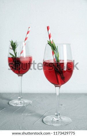 Tasty refreshing cranberry cocktail with rosemary on table