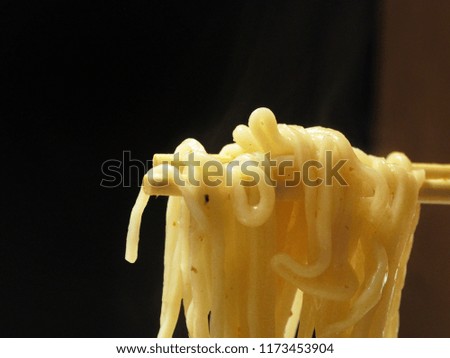 Close up chopsticks noodles isolated on black background.