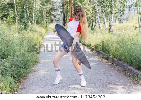 Beautiful skater woman riding on her longboard in the city