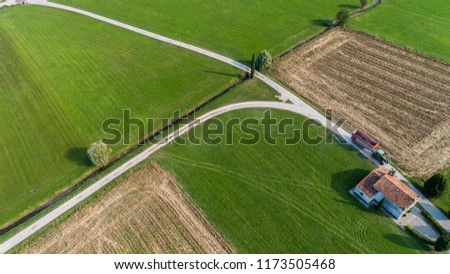 an agricultural tractor on the rural road seen  whith a drone 