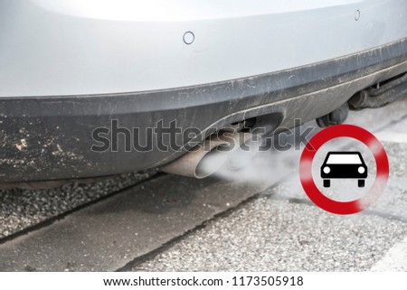 Double exhaust from a car with smoke and the traffic sign for driving ban, in german Fahrverbot for diesel motor vehicles in low emission zones of some cities in Germany, selected focus
