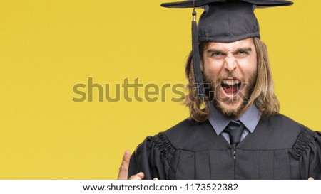 Young handsome graduated man with long hair over isolated background shouting with crazy expression doing rock symbol with hands up. Music star. Heavy concept.