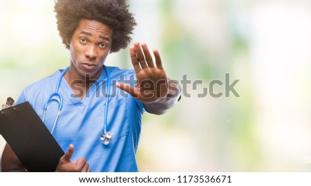 Afro american surgeon doctor holding clipboard man over isolated background with open hand doing stop sign with serious and confident expression, defense gesture