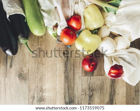 zero waste shopping concept. fresh vegetables in eco cotton bags on table in the kitchen, flat lay.  ban plastic. plastic free items. save environment. space for text
