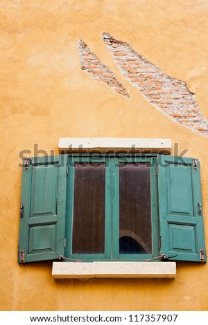 Vintage green wood window on orange wall