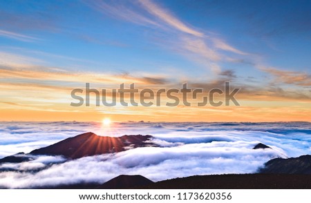 A blazing and colorful morning sunrise over the crater of the dormant volcano Haleakala on the island of Maui, Hawaii Royalty-Free Stock Photo #1173620356