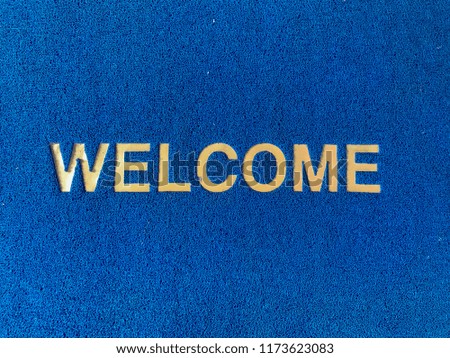 Blue doormat with welcome word.