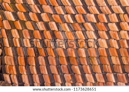 Abstract piles and packs of a new clay ceramic tiles to cover the roof of a Buddhist temple. Stack of new orange roof tiles in the building construction site for background.
