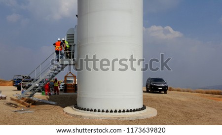 Wind Turbine Towers Installation at Wind Farms on clouds in the blue sky background