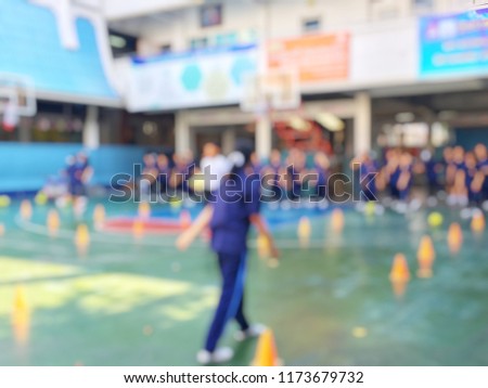 Blurred image of children or male and female students in secondary school are learning football or soccer on school playground in physical education time. Bangkok,Thailand. physical activities concept
