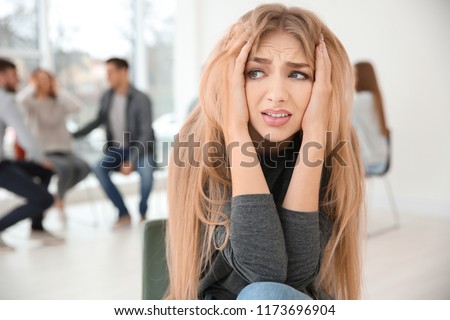 Stressed woman during group therapy, indoors Royalty-Free Stock Photo #1173696904