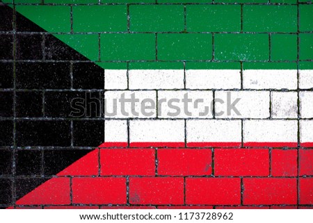 National flag of  Kuwait against a background of a stone background covered with moss