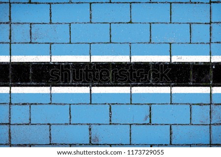National flag of  Botswana against a background of a stone background covered with moss