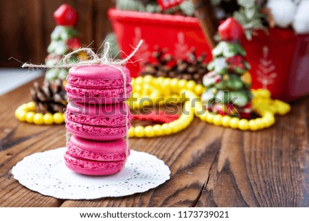 Pink macaroons with christmas decorations on woooden background