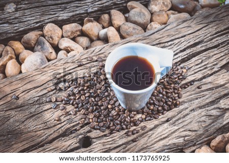 Coffee mug with coffee beans on wooden slab