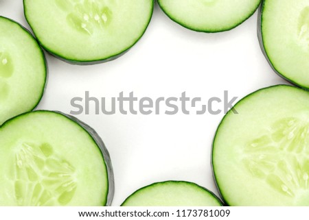 A closeup of a sliced cucumber on white, a fresh background with a place for text