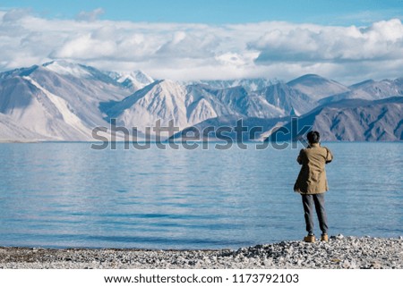 Tourist take a photo at landscape of blue lake and mountain view, at pangong lake, leh ladakh, beautiful nature
