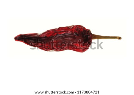 This image shows a red dry chili shot on white background for easy cut out. It is a well composed picture with rich light and shadow play in it. It looks very nice printed out as a huge poster.