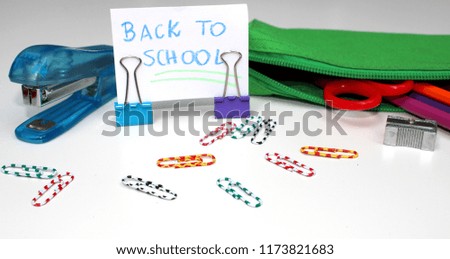Pencil-case with school accessories on a white background